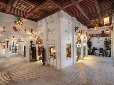 Intérieur d'un hôtel traditionnel avec murs blancs et plafond en bois sculpté.