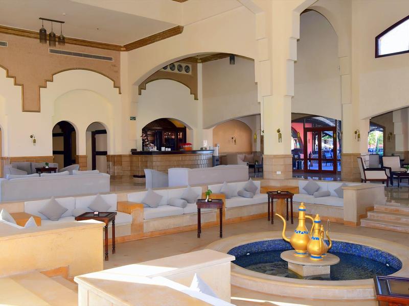 Grand hall d'hôtel lumineux avec canapés, fauteuils et design intérieur moderne.