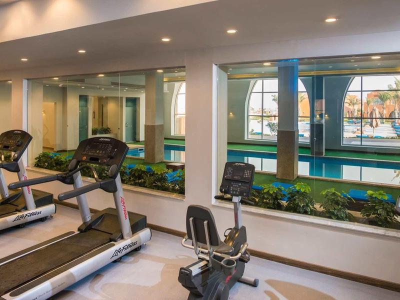 Gym with treadmills and view of indoor pool through large windows