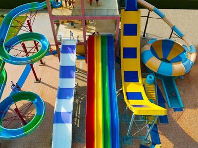 Bunte Wasserrutschen in einem Wasserpark mit verschiedenen Spiralen und geraden Strecken.