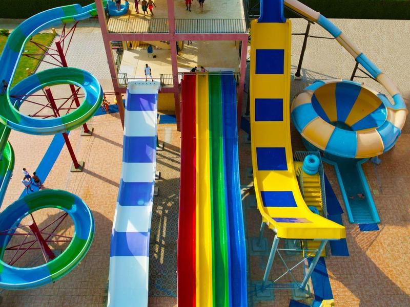 Bunte Wasserrutschen in einem Wasserpark mit verschiedenen Spiralen und geraden Strecken.