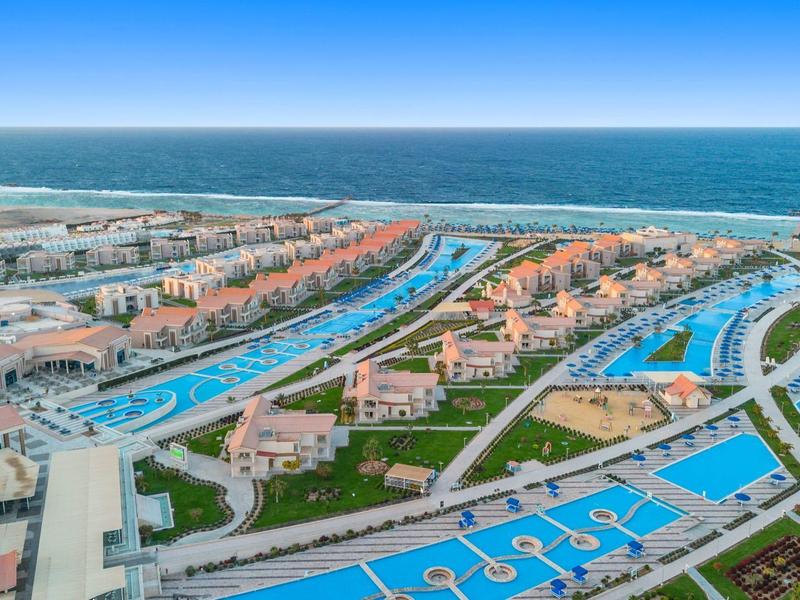 Vue aérienne d'un complexe hôtelier avec plusieurs piscines et accès direct à la mer.