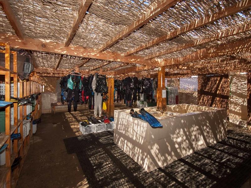 Dachboden mit Holzbalken, Metallfolie an der Decke und Regalen voller Kisten und Taschen.