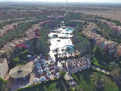 Luftaufnahme eines Resorts mit Schwimmbädern, Umgebungsgebäuden und weiter Landschaft.