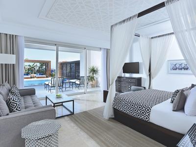 Modernes Schlafzimmer mit Himmelbett, großem Fenster, Blick auf Terrasse und Pool, hell und offen gestaltet.