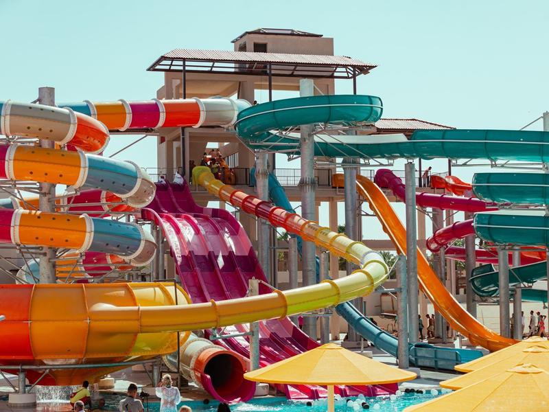 Bunte Wasserrutschen und Rutschbahnen in einem Wasserpark bei klarem Himmel.