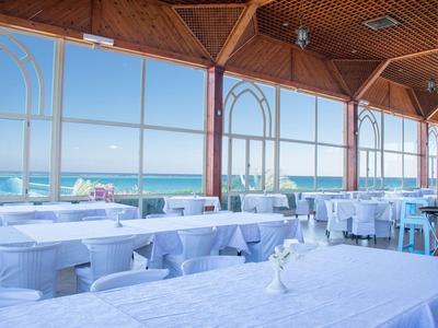 Hell und luftiges Restaurant mit Blick aufs Meer und gedeckten Tischen.