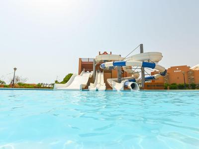 Wasserpark mit mehreren Wasserrutschen und einem großen Pool unter klarem Himmel