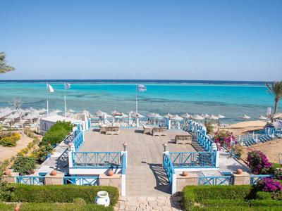 Blick auf den Strand mit Liegen und Sonnenschirmen am Meer bei klarem Himmel