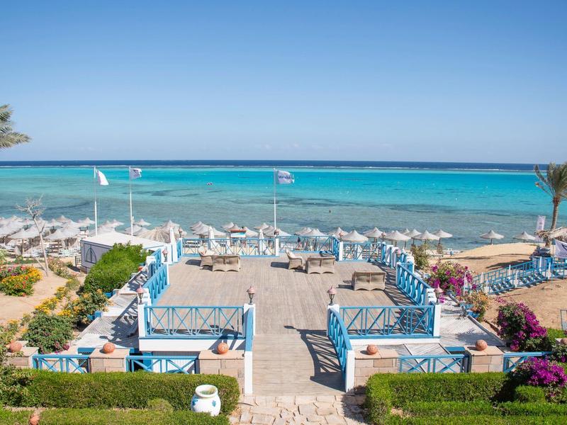 Promenada na plaży z miejscami do siedzenia z widokiem na błękitne morze pod czystym niebem.