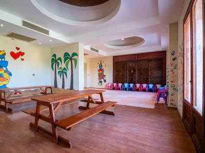 Sala giochi per bambini con tavoli di legno e murales colorati in un hotel