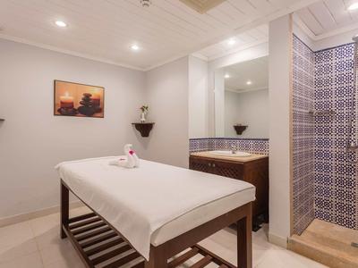 Accogliente sala massaggi con arredi essenziali e asciugamani piegati sul tavolo.