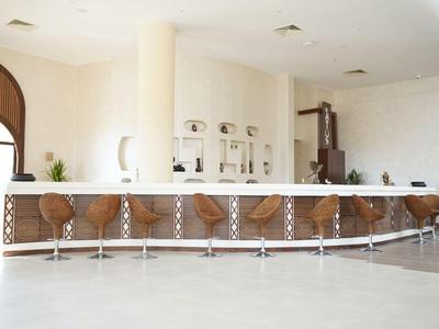 Elegante bar met ronde krukken in een heldere, moderne ruimte.