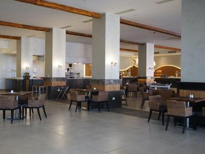 Grote hotel lounge met meerdere zitgedeeltes en moderne verlichting.