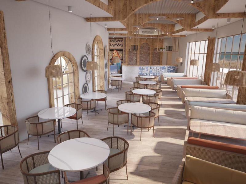 Licht, modern café met ronde tafels, houten en rotan meubels en grote ramen.