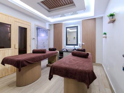 Moderně zařízená masážní místnost se dvěma lehátky a teplým osvětlením.