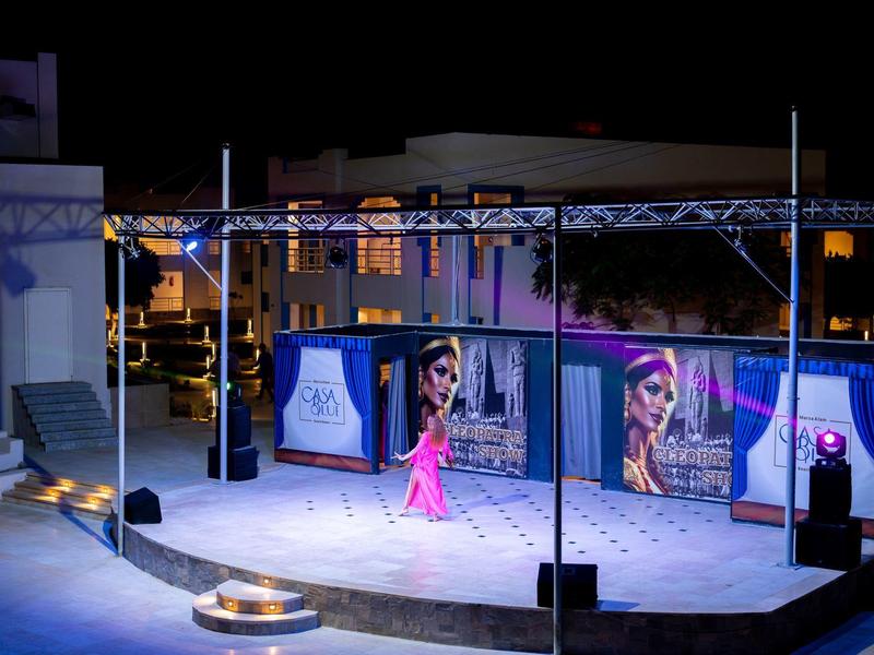 Scéna s osvětlením a plakáty v hotelovém venkovním prostoru v noci