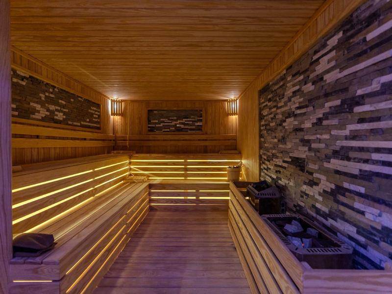 Moderní sauna s dřevěným interiérem a nepřímým osvětlením, útulná a stylová.