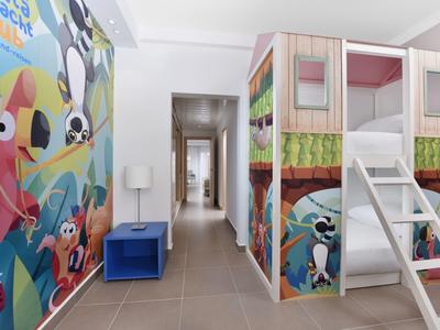 Kinderzimmer mit Hochbett in Holzoptik, bunter Tierwandmalerei und blauem Nachttisch.