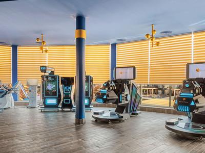 Wnętrze nowoczesnego hotelu z automatycznymi robotami bagażowymi i dużymi oknami.