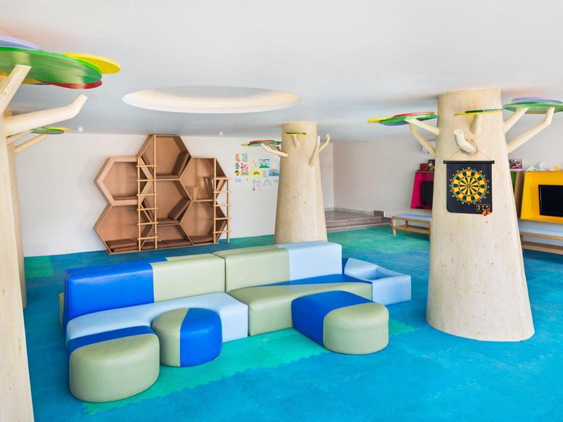 Kolorowa przestrzeń wypoczynkowa z modułową sofą i zabawną dekoracją.