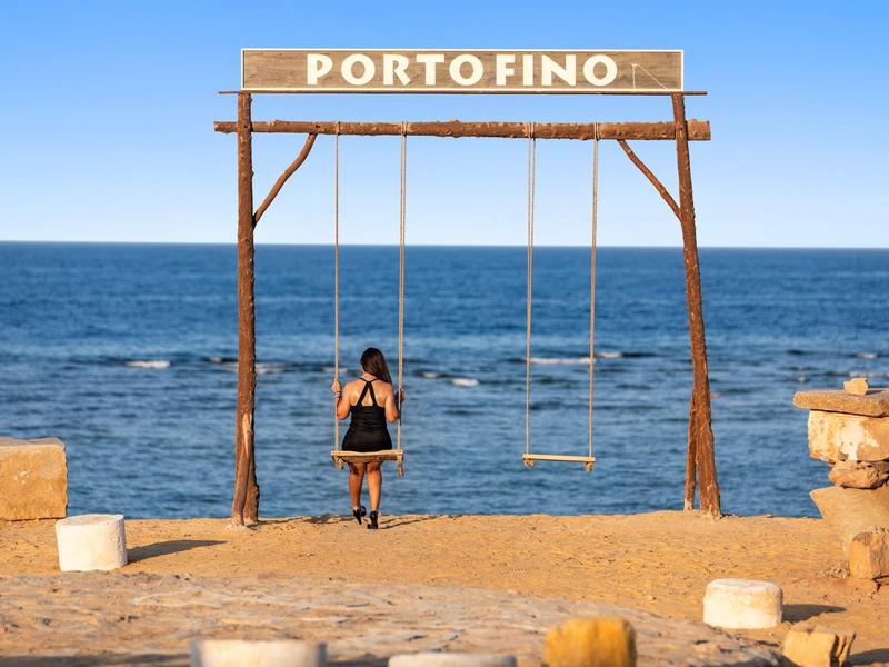 Huśtawka nad brzegiem morza z tablicą Porto Fino pod czystym niebem.