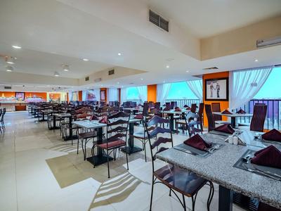 Area ristorante di un hotel moderno con tavoli apparecchiati con stile e sedie nere.