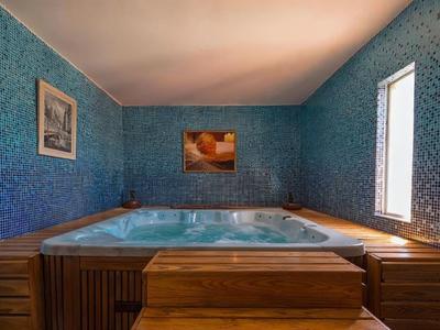 Innenraum eines Hotels mit einem großen Whirlpool und blauen gemusterten Wänden.