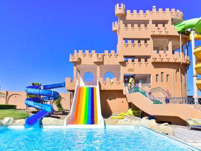 Water park with colorful slides and pool under clear blue sky.