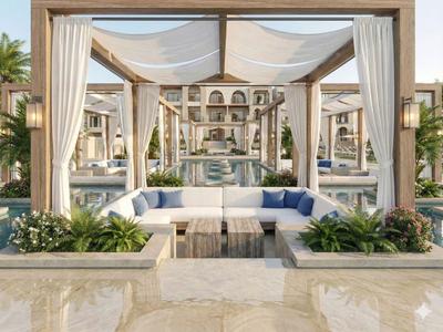 Coin lounge blanc luxueux avec coussins et plantes dans un cadre hôtelier avec pergola.