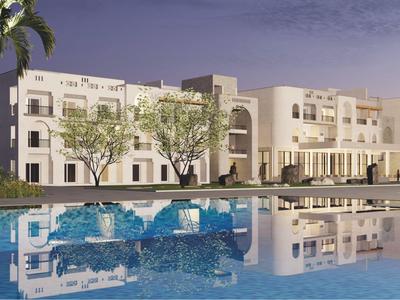 Grand hôtel moderne avec piscine et palmiers entouré d'arbres au crépuscule.