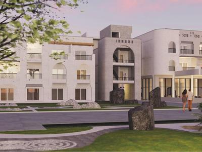 Bâtiment hôtelier moderne aux façades blanches, entouré de verdure et de chemins au coucher du soleil.