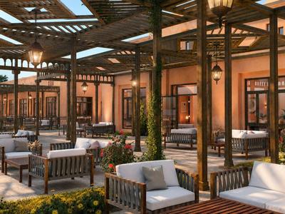 Area lounge esterna dell'hotel con pergola in legno e comodi divani bianchi.