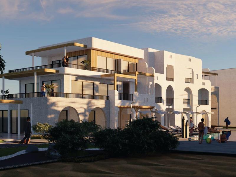 Modern hotel building with white facades and large balconies under a blue sky.