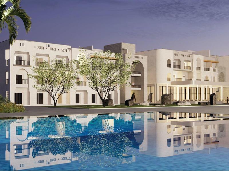 A large multi-story hotel building with an outdoor heated pool at dusk.