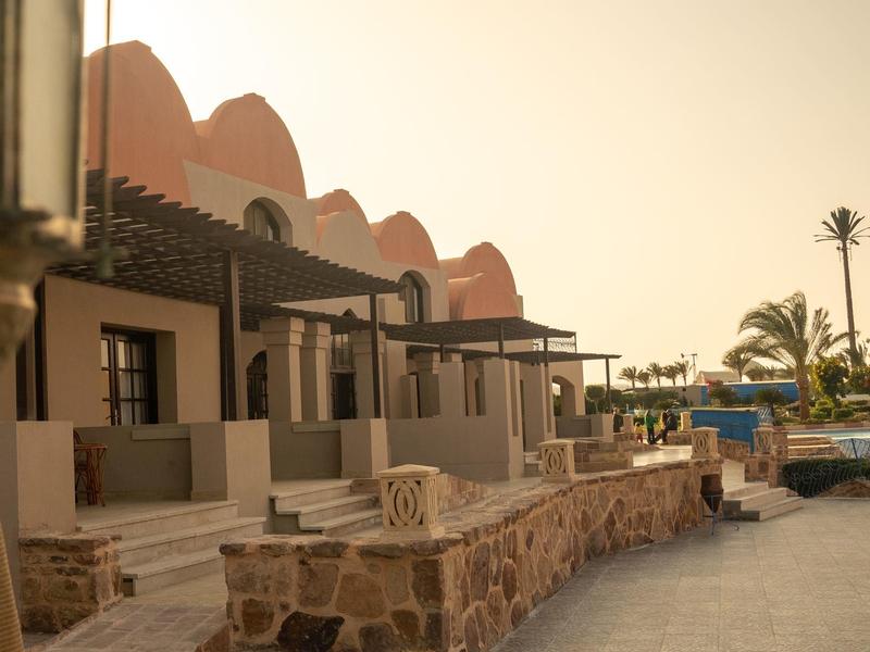 Bungalows en rangée avec fondation en pierre et pergola près d'une piscine au coucher du soleil