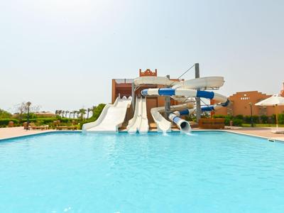 Grande piscina con scivoli d'acqua e ombrelloni sotto un cielo limpido