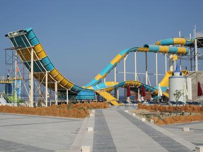 Toboggan aquatique coloré en forme de vague dans un parc aquatique sous un ciel dégagé