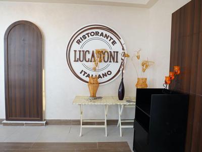 Eingangsbereich eines italienischen Restaurants mit runder Tür und einfacher Deko.