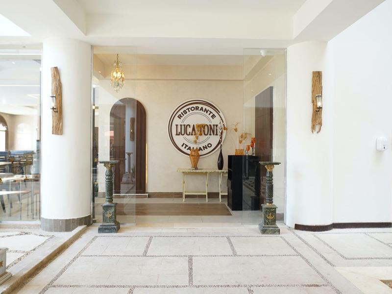 Hall d'hôtel lumineux avec grandes fenêtres, intérieur blanc et design minimaliste.