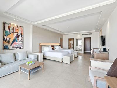 Modernes Hotelzimmer mit gemütlichem Sofa, Kingsize-Bett und hellem Interieur.
