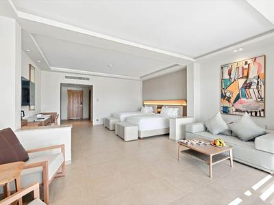 Helles Hotelzimmer mit zwei Betten, Sitzbereich und modernem Dekor.