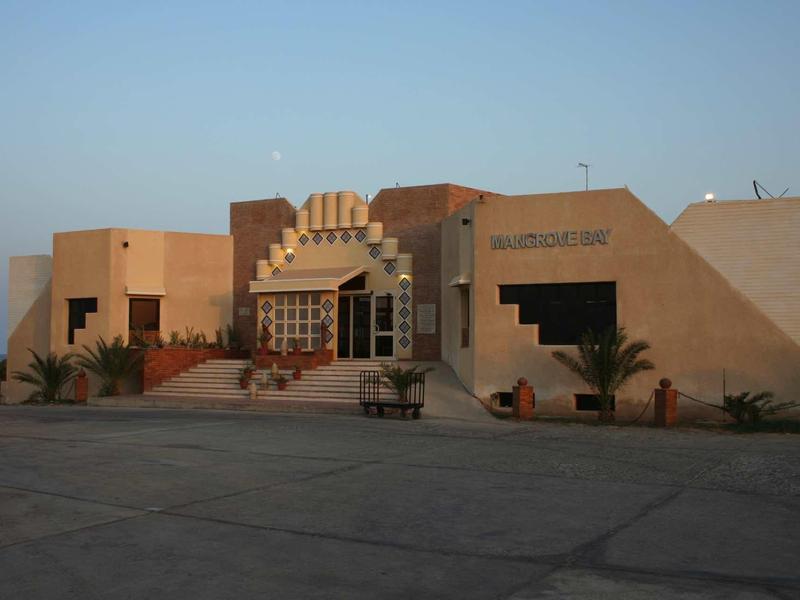 Bâtiment d'hôtel plat avec escaliers, grandes fenêtres et architecture géométrique au coucher du soleil.