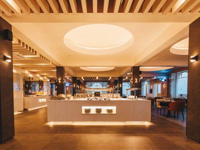 Modern eingerichteter Hotelbarbereich mit zentralem Tresen, warmen Lichtakzenten und Holzdecken.