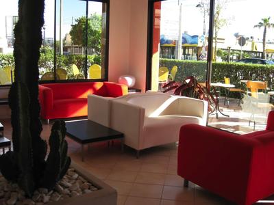 Gemütlicher Sitzbereich mit rotem und weißem Sofa, modernem Tisch und großem Fenster zur Terrasse.