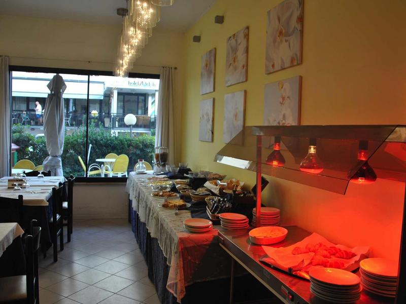 Area buffet in un ristorante luminoso con illuminazione calda e allestimenti tavola.