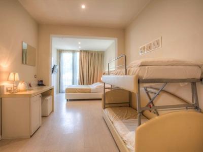 Hell eingerichtetes Schlafzimmer mit Etagenbett, großem Fenster und hellem Holzmöbel.