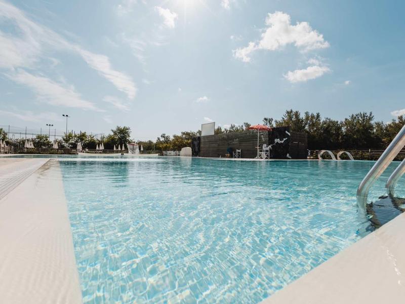 Large outdoor pool with clear water and blue sky in the background.