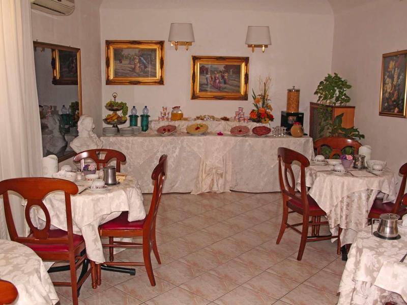 Cozy breakfast room with several tables and buffet in a bright space.