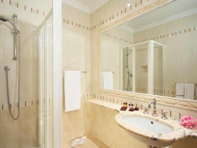 Modern bathroom with shower, sink, and large mirrors in a bright design.